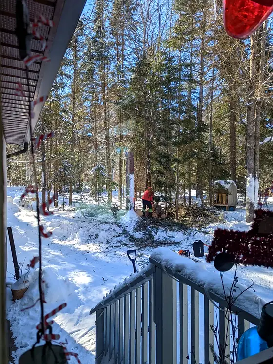 A Rorco climber up a spar in deep winter, working a few metres from the side of a house.